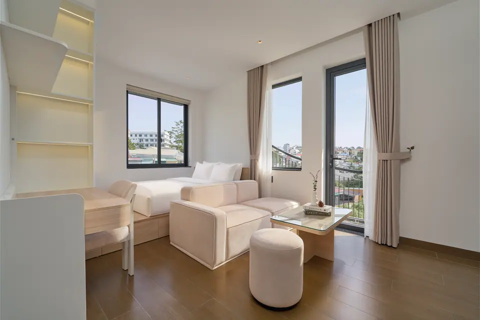 Light-oak studio with a bed, a sofa and a balcony door