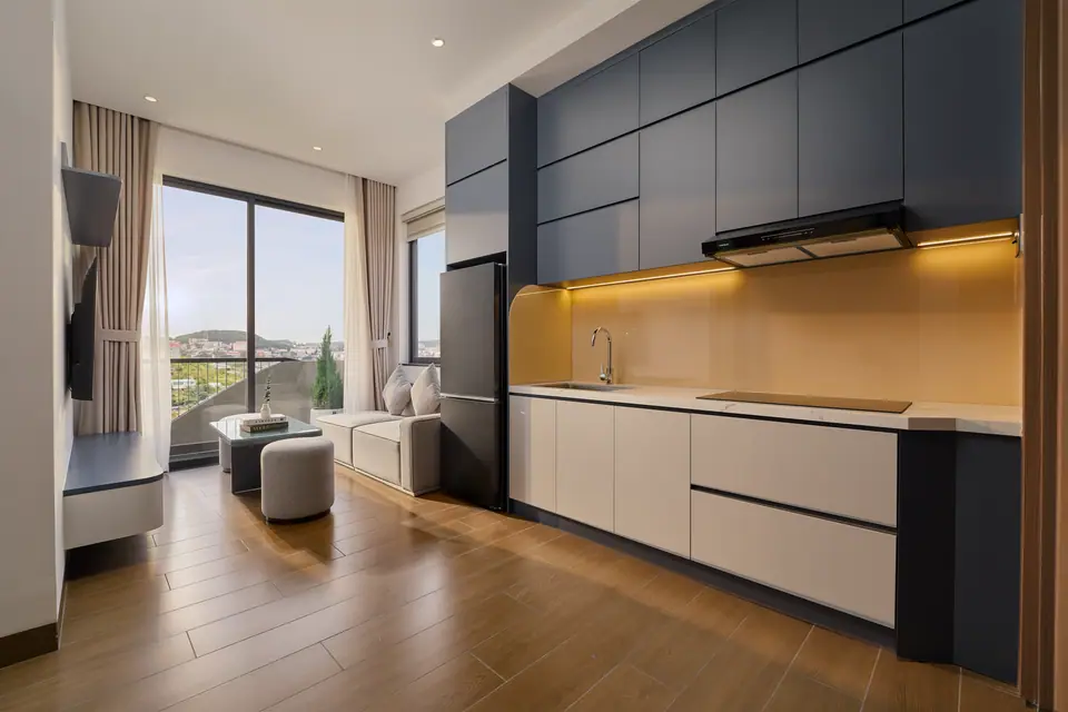 Long navy kitchen opening onto the living room and balcony