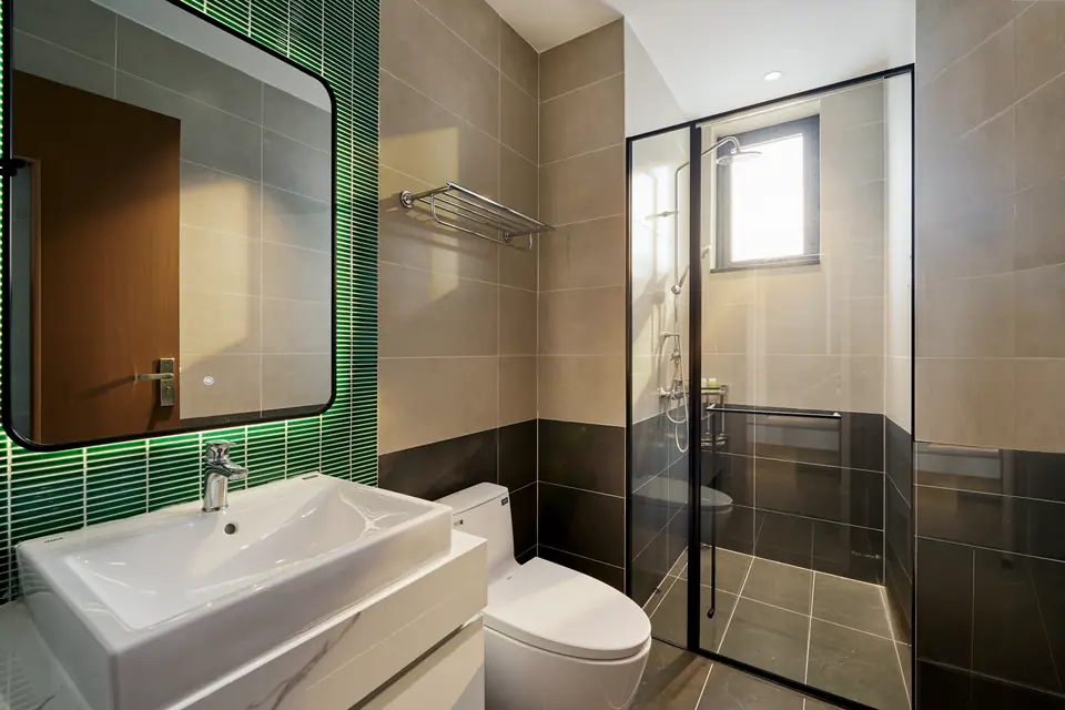 Glass shower and a green-tiled vanity
